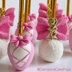 pink and white candies with bows on them are lined up against gold poles in front of each other