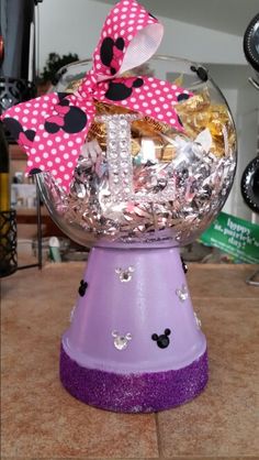 a bowl filled with lots of candy and minnie mouse ears on top of a table