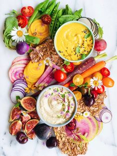 an assortment of fruits and vegetables on a marble counter top, with dip in the middle