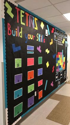 a bulletin board that says tetris build your skills on the wall in an office