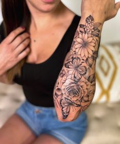 a woman with a flower tattoo on her arm and hand is posing for the camera