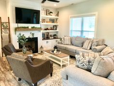 a living room filled with furniture and a flat screen tv mounted on the wall above a fireplace