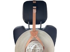 a hat is hanging from the back of a suitcase with a leather strap around it