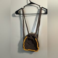 a crocheted purse hanging on a coat hanger with two strings attached to it