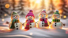 three snowmen with hats and scarves standing in the snow