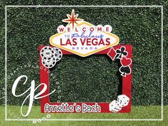 the welcome sign to las vegas is displayed in front of a green wall with grass