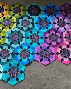 four hexagons are arranged on the floor to make a colorful quilt pattern