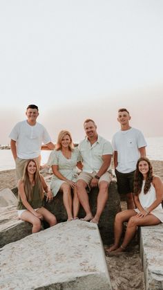 a group of people sitting next to each other on top of cement blocks in front of the ocean