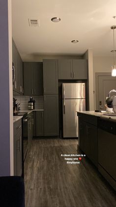 an empty kitchen with stainless steel appliances and wood flooring is pictured in this image