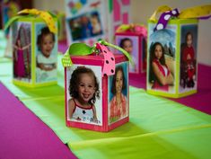 small boxes with pictures on them are sitting on a green and pink tableclothed