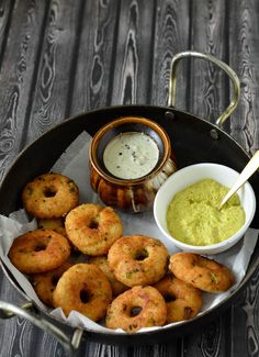 a pan filled with onion rings and dipping sauce