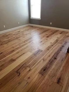 an empty room with hard wood flooring and gray walls in the corner is shown