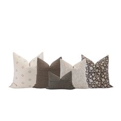 four pillows with different patterns on them, one is white and the other is brown