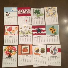 several calendars with pictures of flowers and animals are arranged on a wooden table top