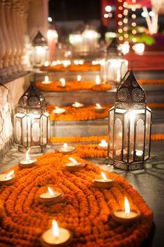 many lit candles are placed on the ground