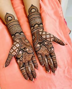 two hands with henna tattoos on them