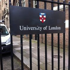 a sign that reads university of london behind a fence in front of a brick building