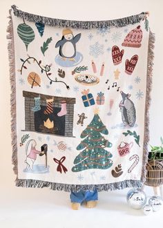 a christmas quilt hanging on the wall next to a potted plant and other decorations