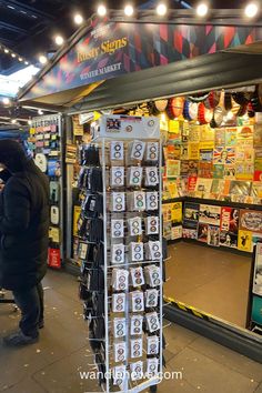 a man standing in front of a store with lots of cards on the display rack