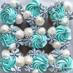 cupcakes decorated with blue and white frosting are arranged in the shape of a heart