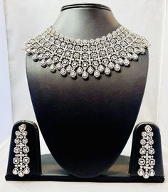 American Diamond Bridal Necklace Set--a perfect blend of elegance and contemporary design, ideal for your special day. Despite its dramatic appearance, the necklace is lightweight, ensuring comfort while wearing it throughout your special day. his necklace pairs beautifully with traditional outfits like lehengas and sarees, as well as modern gowns, adding a touch of glamour to any look Dazzling Necklace With Elegant Design For Festive Season, Traditional Silver Diamond Necklace For Festive Season, Diamond White Necklaces For Reception, Festive Dazzling Bridal Necklace With Elegant Design, Silver Diamond Necklace For Formal Festive Occasions, Elegant Hand-set Kundan Necklace For Reception, Elegant Hand Set Kundan Necklace For Reception, Elegant Kundan Hand-set Necklace For Reception, Festive Silver Diamond Necklace For Formal Occasions