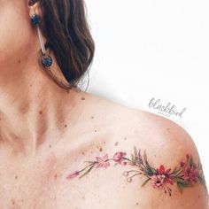 a woman's chest with flowers painted on it and ear piercings attached to the side