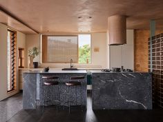 a kitchen with marble counter tops and bar stools