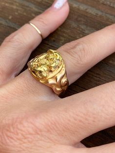 The rich buttery color of the natural gold nugget is absolutely delicious, and due to the purity of the gold and the solid make of the ring, it has such a heavy, solid feel.  It fits so comfortably on the finger and is perfect for every day wear. The mounting holding the nugget is made of yellow gold. It is not stamped but guaranteed to be 14k.  Due to tthe different gold contents, the coloration of the nugget and the ring are quite different which adds to its unique beauty.  The mounting is a r Natural Gold Nugget, The Nugget, Gold Nugget, Gold Signet Ring, Natural Gold, Unique Beauty, Feel It, Signet Ring, Rings Statement