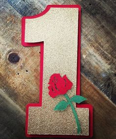 the number one has a rose on it and is made out of glittery material