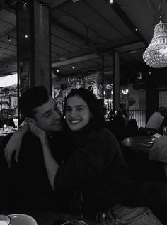 a man and woman sitting next to each other at a table