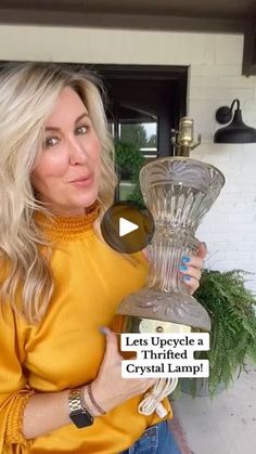 a woman holding a crystal lamp in front of a white brick wall with the caption let's investigate a hybrid crystal lamp