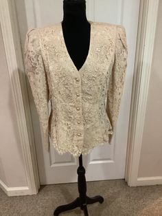 This beautiful 90s Cachet Cream Lace fitted pearl button down fitted Cottage core like Regency appliqués jacket top comes to you in a size 14. Such a beautiful jacket- please compare the measurements I give you to those in your closet. They are as follows- Fitted Button-up Blouse With Pearl Buttons, Formal Fitted Tops With Pearl Buttons, Elegant Puff Sleeve Outerwear, Elegant Fitted Puff Sleeve Outerwear, Fitted Blouse With Button Closure For Wedding, Fitted Wedding Blouse With Button Closure, Fitted Winter Blouse With Button Closure, Fitted Button Closure Blouse For Winter, Fitted Blouse With Button Closure For Winter