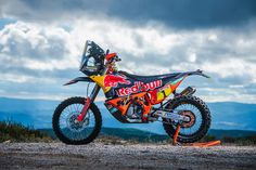 a red bull dirt bike parked on top of a hill