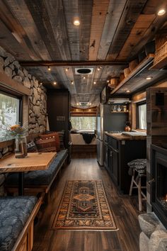 the interior of a mobile home with wood flooring and stone walls, along with an area rug