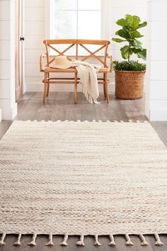 a wooden bench sitting next to a white rug