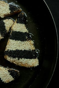 two pieces of cake are being cooked in a skillet on the stove top, with black and white stripes