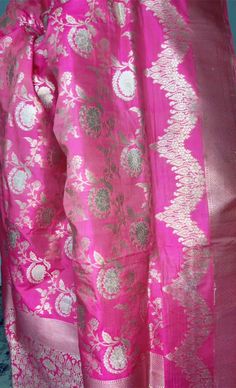 This stunning pink 100% Mulberry Katan silk saree is handwoven in Banaras, known for its intricate designs and high-quality craftsmanship. The saree features a beautiful shade of dual pink with gold and silver zari jaal work creating a mesmerizing effect. Loolong for a distinct saree - this is the one with silver zari outlining . The saree is perfect for any special occasion, such as a wedding, festival, or formal event. Comes finished with hand fall and Pico. And a blouse piece with zari border. Silk Mark Certified Note: Colors that show up on your screen may vary slightly from the actual product due to variations in settings. Also, the actual product may appear to be different hues depending on the ambience lighting.Note: There may be very slight inconsistencies such as in the weave/moti Festive Pink Katan Silk Salwar Kameez, Pink Anarkali Katan Silk Salwar Kameez, Pink Raw Silk Traditional Wear For Ceremonies, Traditional Drape Blouse Piece In Pink For Celebrations, Pink Saree For Celebration With Traditional Drape, Traditional Drape Pink Blouse Piece For Celebration, Pink Traditional Drape Blouse Piece For Celebration, Pink Blouse Piece For Celebration, Pink Zari Work Saree For Celebration