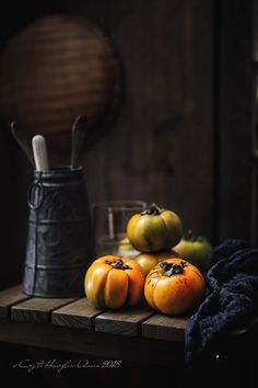 some oranges are sitting on a wooden table