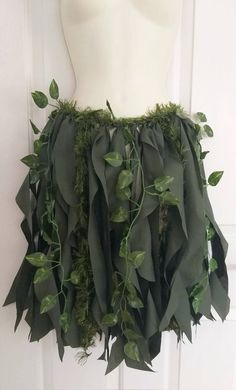 a white mannequin with green leaves on it