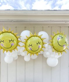 three yellow and white balloons with faces on them