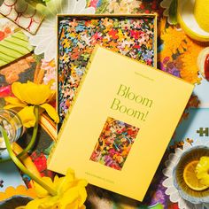 a yellow book sitting on top of a table next to flowers and other items in front of it