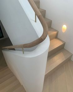 a wooden handrail on the side of a white staircase