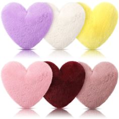 four heart shaped cushions in different colors