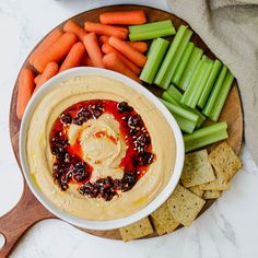 carrots, celery and crackers on a plate with dip