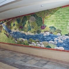 a large mural on the side of a wall in an empty room with tile flooring