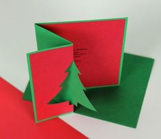 an origami christmas card with a tree cut out of the front and bottom