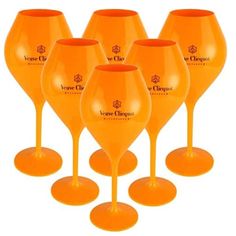 six orange wine glasses sitting next to each other