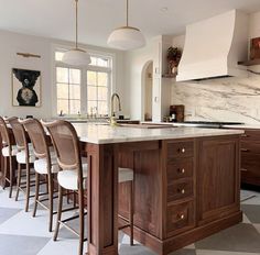 a large kitchen with an island in the middle and lots of stools around it