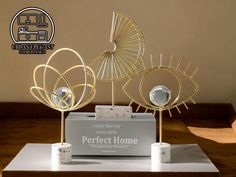 three decorative items sitting on top of a wooden table in front of a sign that says perfect home