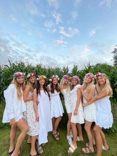 a group of women standing next to each other on top of a lush green field